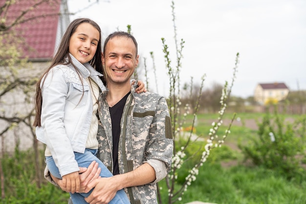 Soldier reunited with his daughter on a sunny day.