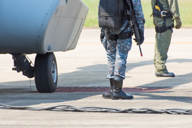 Soldier's leg with military boot in the forefront and helicopter