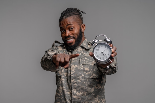 Soldier showing his mechanical windup twin bell alarm clock