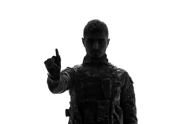 Soldier silhouette serious handsome strong tough army soldier in uniform pointing with hand