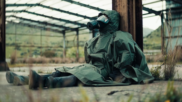 Soldier with gas mask is resting on the ground