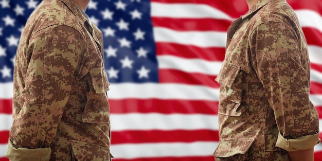 Soldiers in American military digital pattern uniforms standing on a USA flag background