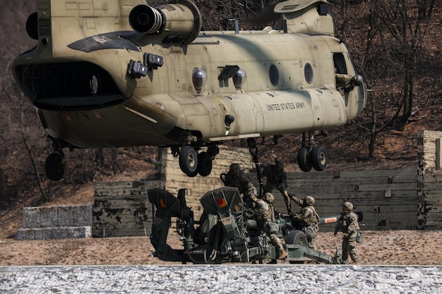 Soldiers from the army are loading a military helicopter.