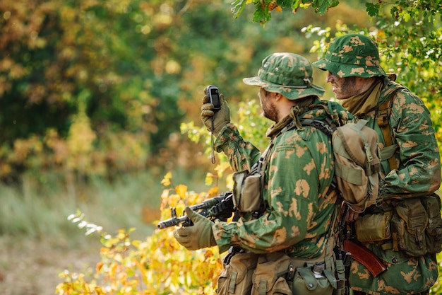 Soldiers holding gps in hand and determines the location of coordinates