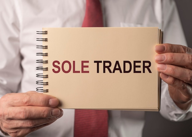 Sole trader text on note in hand of man