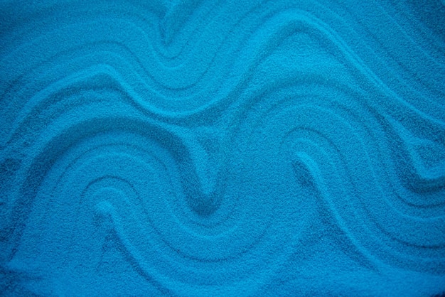 Solid blue sand with different patterns blue turquoise color Drawing in the sand