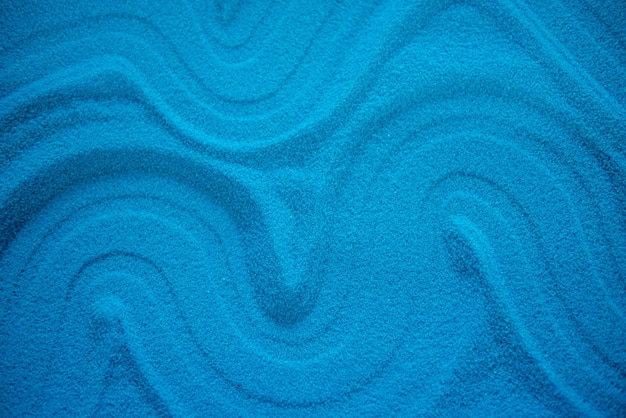 Solid blue sand with different patterns blue turquoise color Drawing in the sand