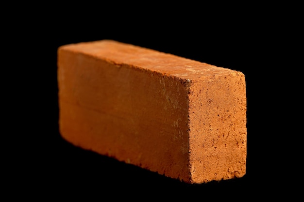 Solid clay bricks used in construction are laid on a black background