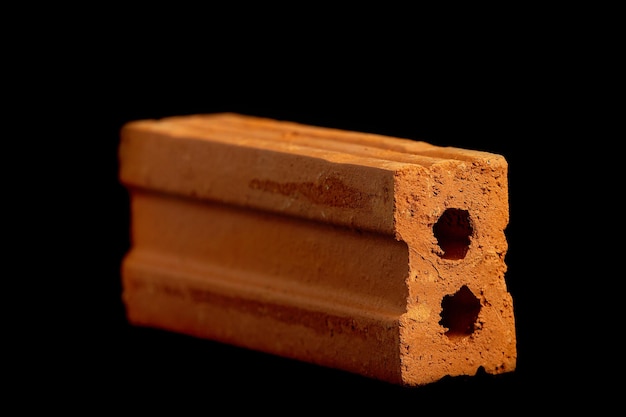 Solid clay bricks used in construction are laid on a black background