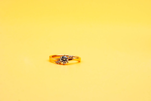 Solitaire engagement ring round cut yellow background