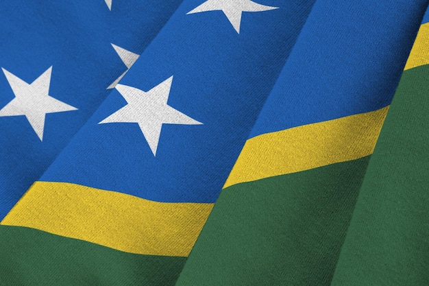 Solomon islands flag with big folds waving close up under the studio light indoors the official symb