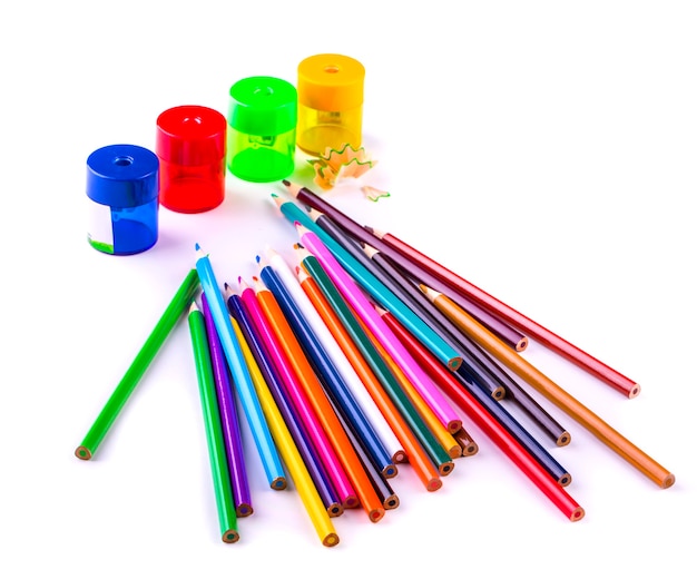 Some colored pencils of different colors and a pencil sharpeners and pencil shavings isolated