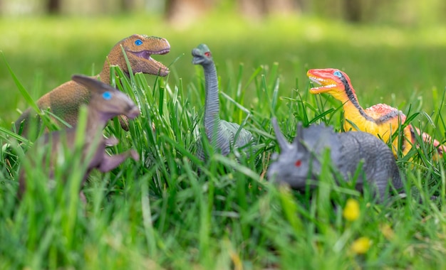 some dinosaurs toys in the green grass happy dinosaur day may 15 and june 1 fascinating dinosaur