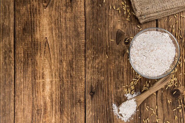 Some fresh Oat Flour on wooden background selective focus closeup shot