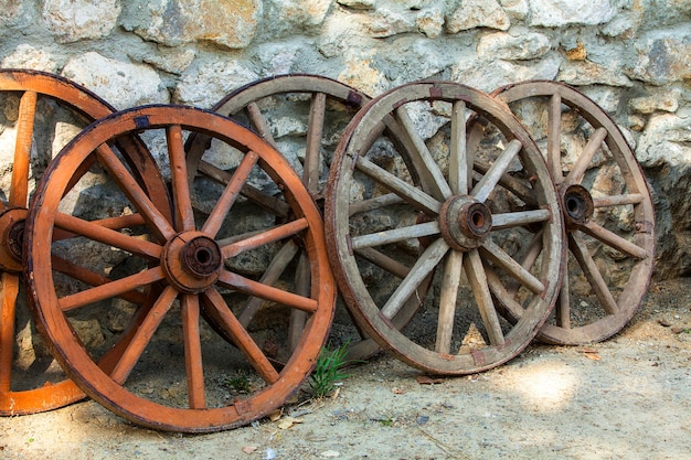 Some historic abandoned faded wooden cart wheels together