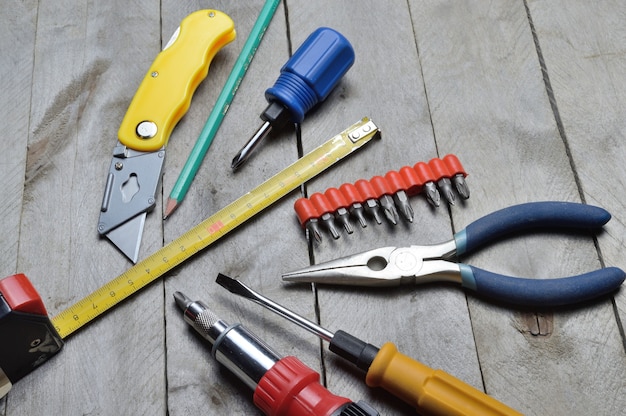 Some home repair tools lie on a wooden background. close-up.