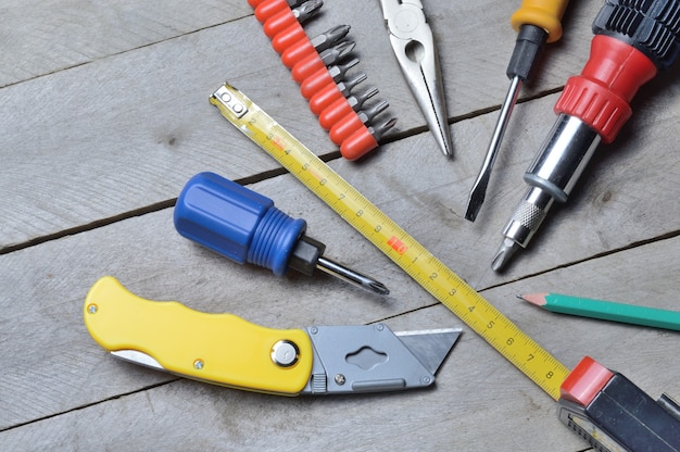 Some home repair tools lie on a wooden background. close-up.