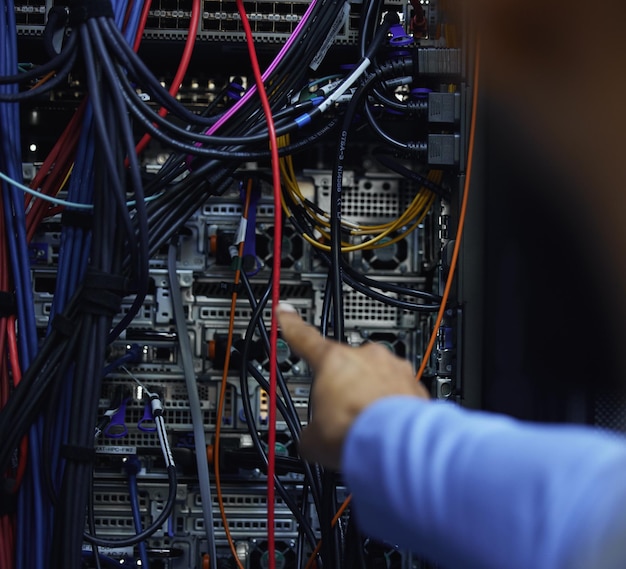 Sometimes its just a matter of connecting point A to point B Cropped shot of an unrecognizable male IT support agent working in a dark network server room