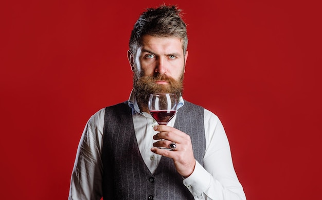 Sommelier with red wine in glass winemaker checking wine quality bearded man with wineglass