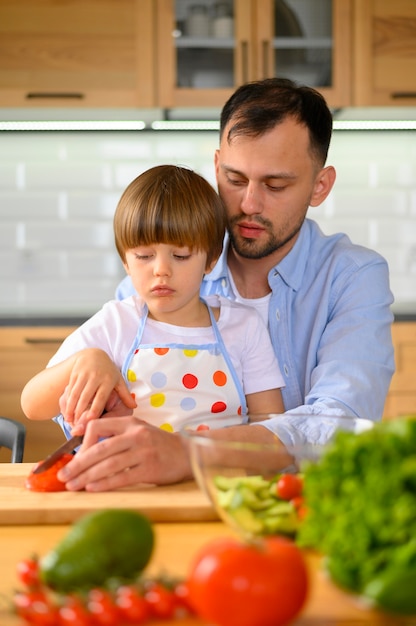 Son and dad cutting tomatoes