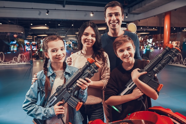 Son and daughter are shooting guns in arcade.