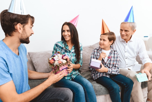 Son and father in law congratulate mother on birthday.