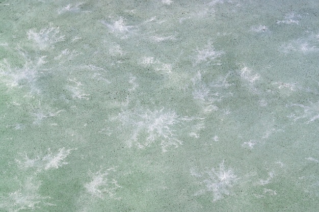 Soot on ice against a white pattern similar to snowflakes