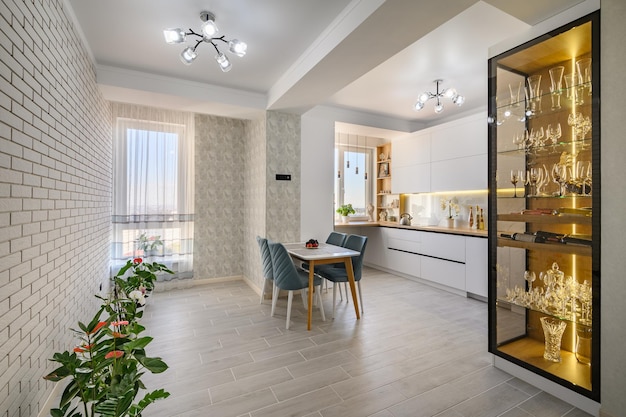 A sophisticated white studio apartment with a kitchen tand dining table