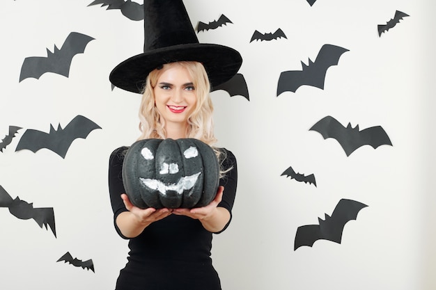 Sorceress holding black Halloween pumpkin