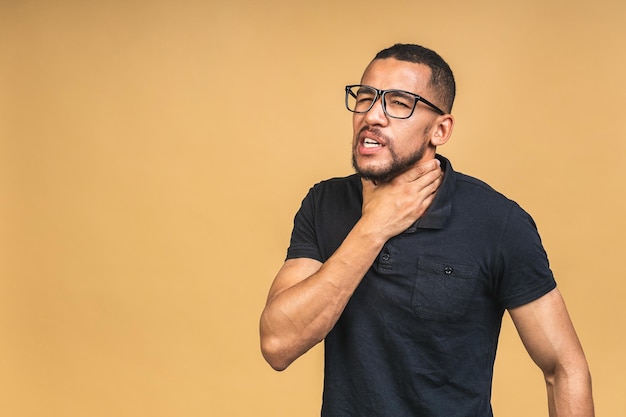 Sore throat African american black man touching the neck isolated over beige background Virus flu concept