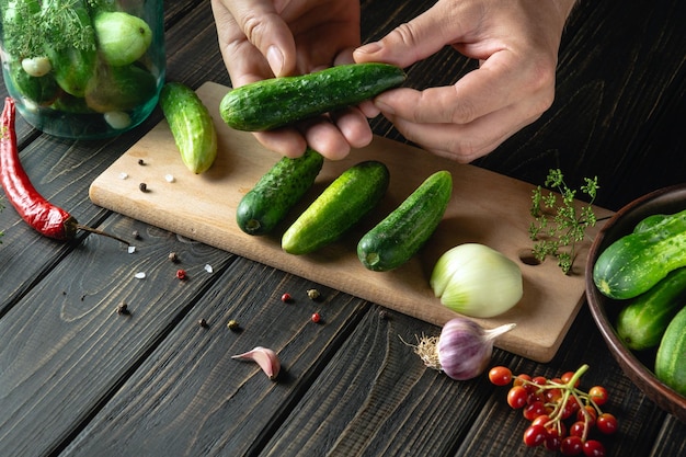 Sorting cucumbers before canning in a jar Chef hands closeup while working on the kitchen table