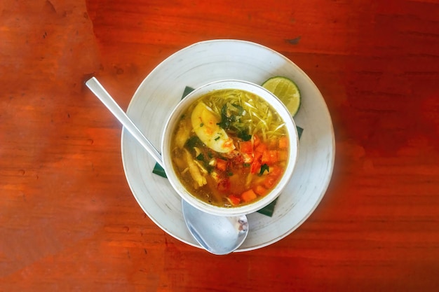 soto ayam traditional cuisine from Indonesia with brown wood background