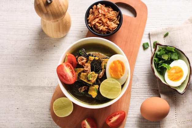 Soto Babat Traditional Indonesian Soup made from Broth and Tripe Served in A Bowl with Egg and Tomato