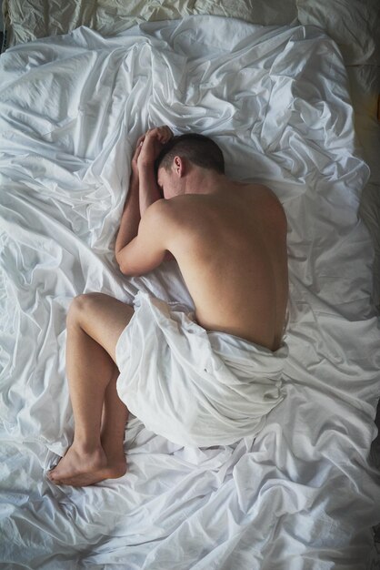 Sound asleep Shot of a shirtless young man sleeping in his bedroom