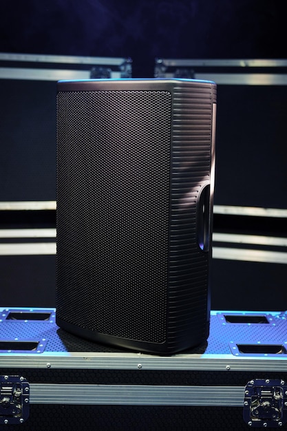 A sound speaker standing on boxes with concert equipment