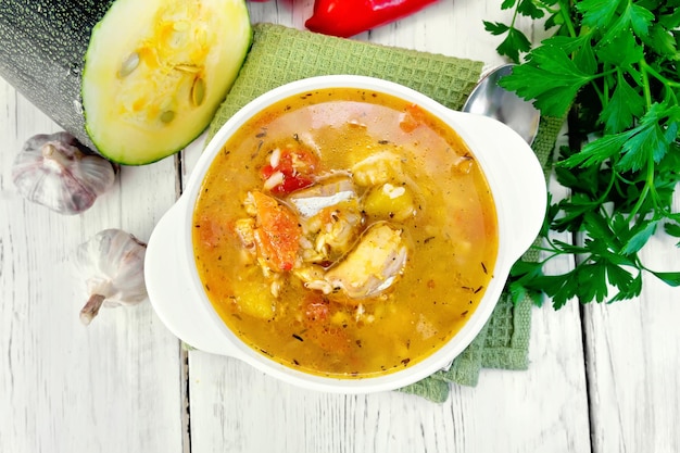 Soup fish with zucchini and peppers on board top