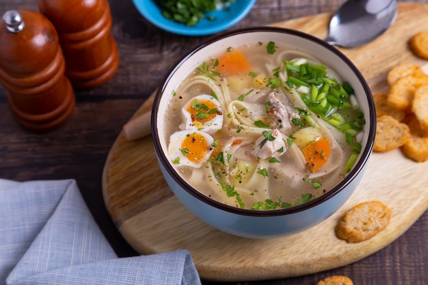 Soup with chicken, noodles, potatoes, quail eggs and carrots