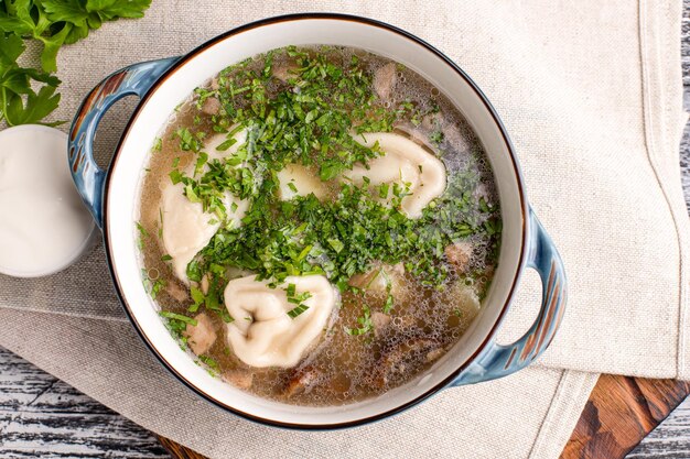 Soup with dumplings soup with homemade dumplings on a wooden white background