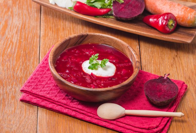 Soup with red beets in wooden bowl Russian traditional dish Borsch