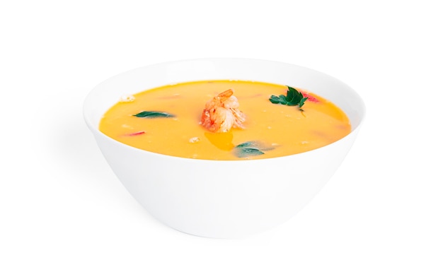 Soup with shrimps in a white deep dish isolated. Thai soup with seafood. Thai tom yum soup.