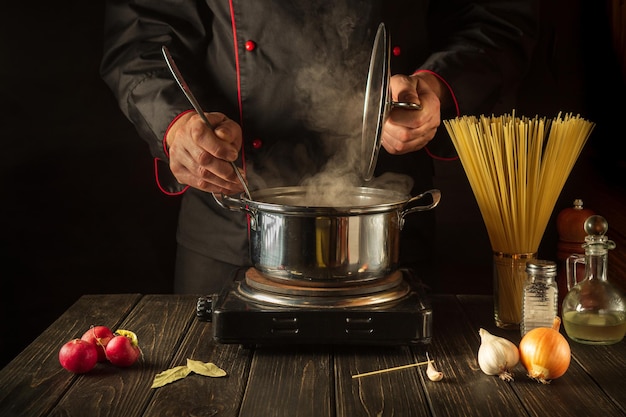 Soup with spaghetti while preparing dinner Cook while cooking in the kitchen Molecular gastronomy