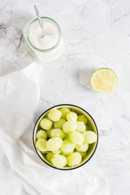 Sour candy grapes in a bowl lime and sugar Social media candy trend Top and vertical view