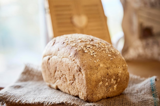 Sourdough unleavened bread with oatmeal on rustic sackling Loaf of natural freshly baked bread Beige rustic food background