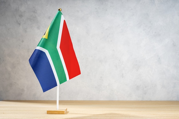 South Africa table flag on white textured wall. Copy space for text, designs or drawings