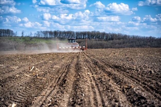 Sowing work in the field. Tractor with seeder.