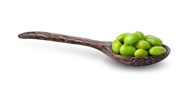 Soy beans in wood spoon isolated on white background