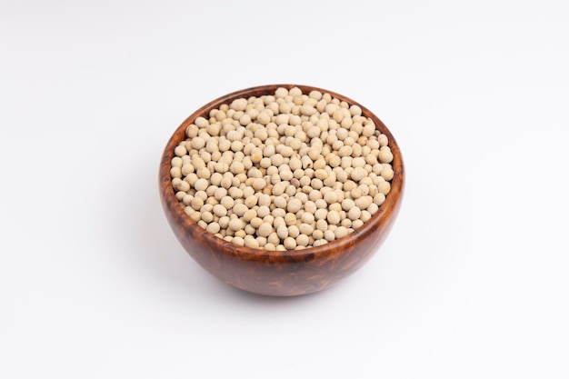 Soy beans in a wooden bowl on white background