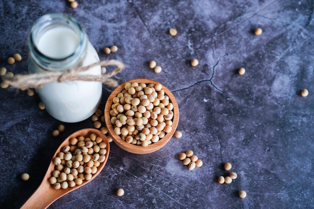 Soy milk in a glass with soybeans in wooden cup