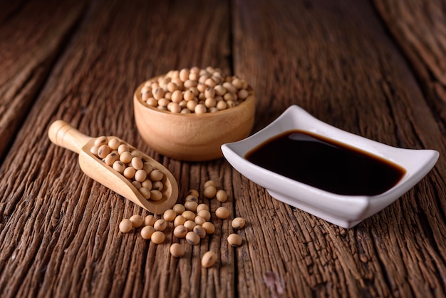 Soy Sauce with soy bean on wooden background.