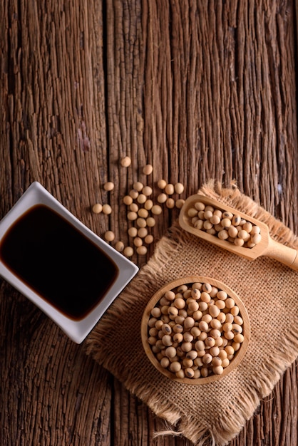 Soy Sauce with soy bean on wooden background.